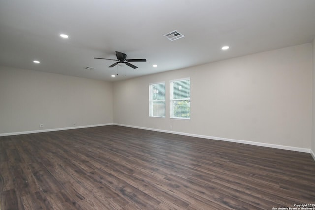 unfurnished room with baseboards, visible vents, dark wood finished floors, and recessed lighting