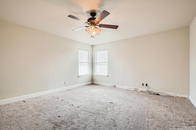 carpeted empty room with a textured ceiling, ceiling fan, a textured wall, and baseboards