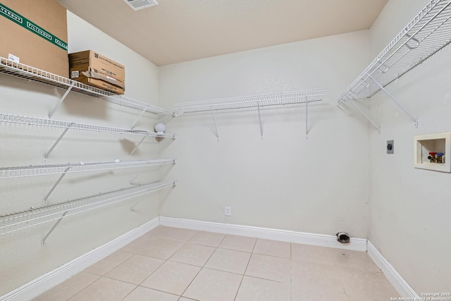 laundry room featuring laundry area, baseboards, tile patterned flooring, washer hookup, and electric dryer hookup