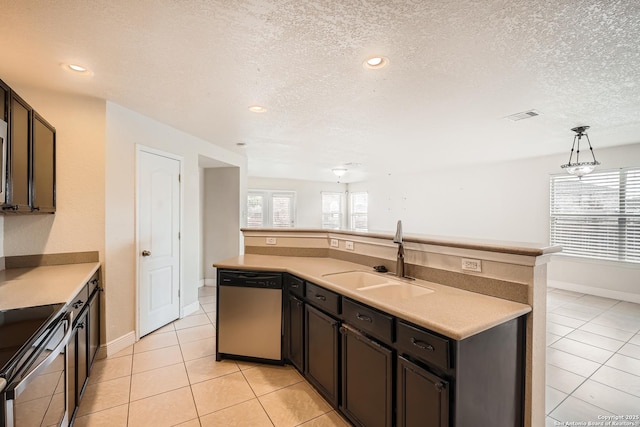 kitchen featuring light tile patterned floors, hanging light fixtures, stainless steel appliances, light countertops, and a sink