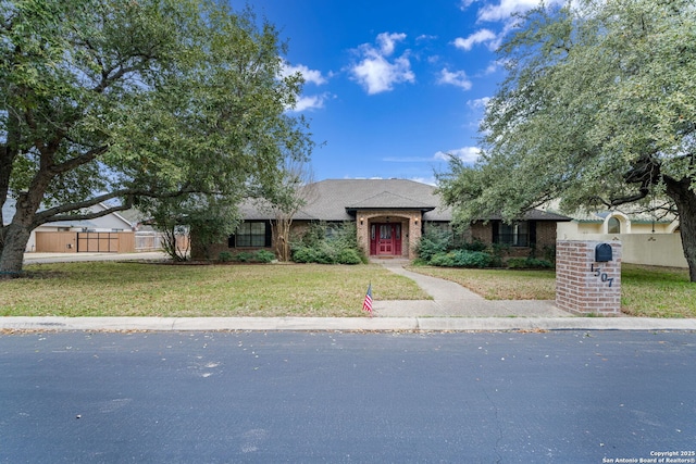 view of front of property featuring brick siding, a front yard, and fence