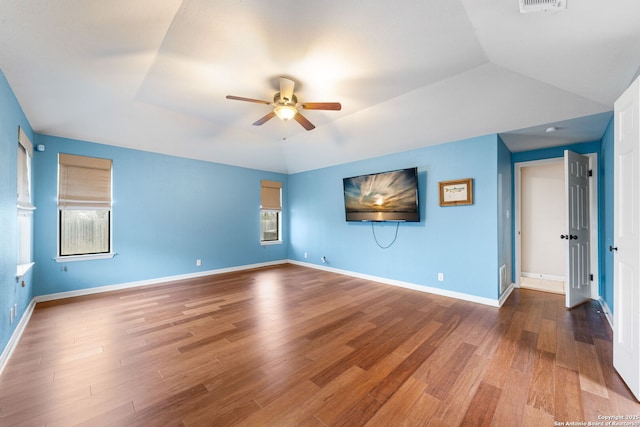 unfurnished room featuring ceiling fan, vaulted ceiling, wood finished floors, and baseboards