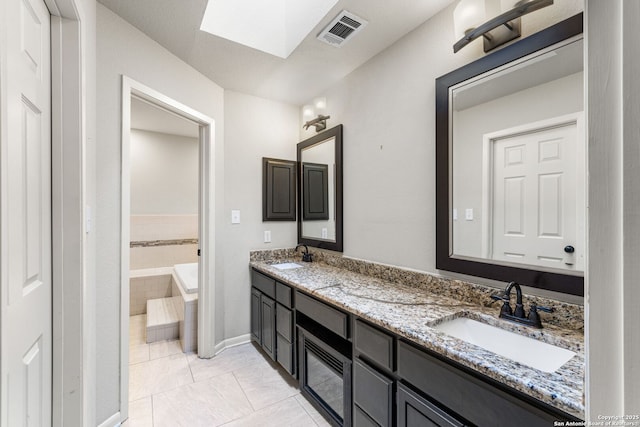 bathroom with visible vents, a sink, a garden tub, and double vanity