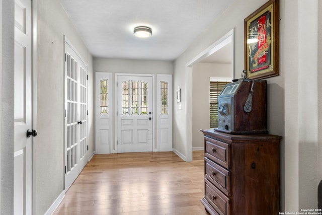 entryway with light wood-type flooring and baseboards