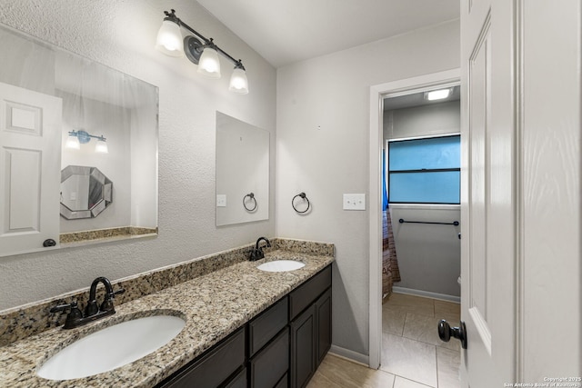 full bathroom featuring tile patterned flooring, a sink, baseboards, and double vanity