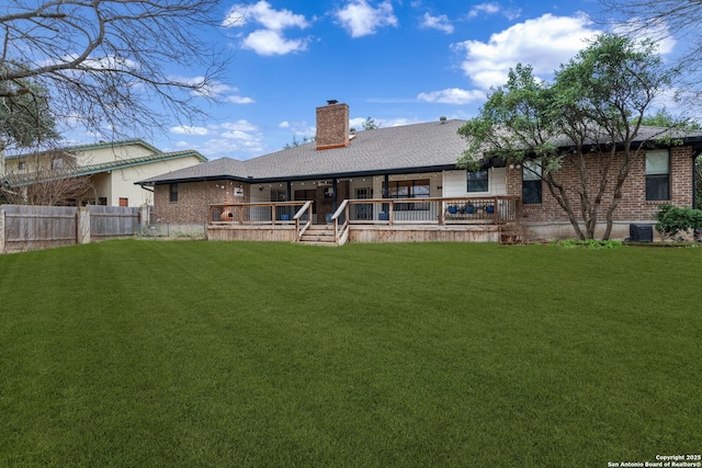 back of property featuring brick siding, a yard, a chimney, fence, and cooling unit