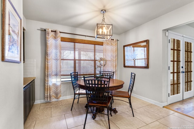 dining area with french doors, light tile patterned floors, baseboards, and an inviting chandelier