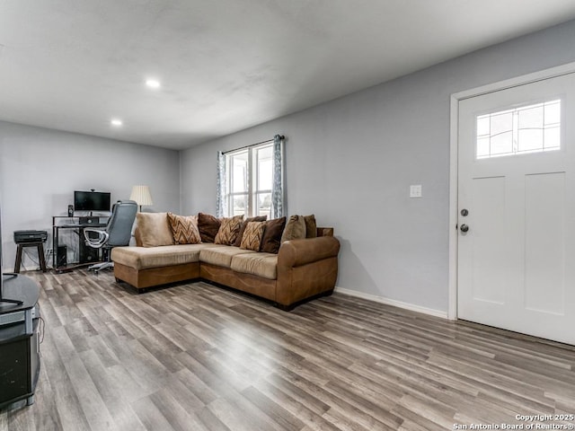 living area with baseboards, light wood-type flooring, and recessed lighting