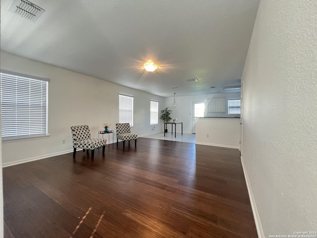 unfurnished room with dark wood finished floors, visible vents, and baseboards