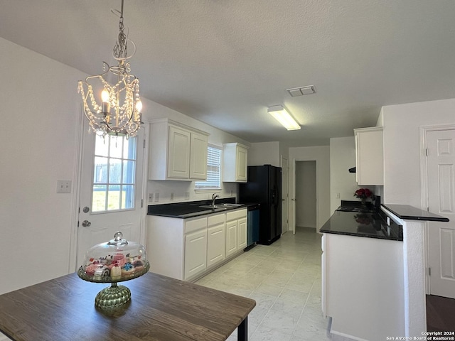 kitchen with a sink, visible vents, white cabinetry, stainless steel dishwasher, and dark countertops