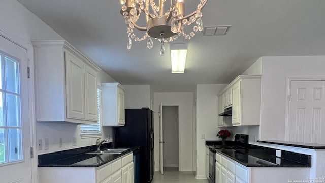 kitchen featuring dark countertops, electric range, white cabinetry, and a sink