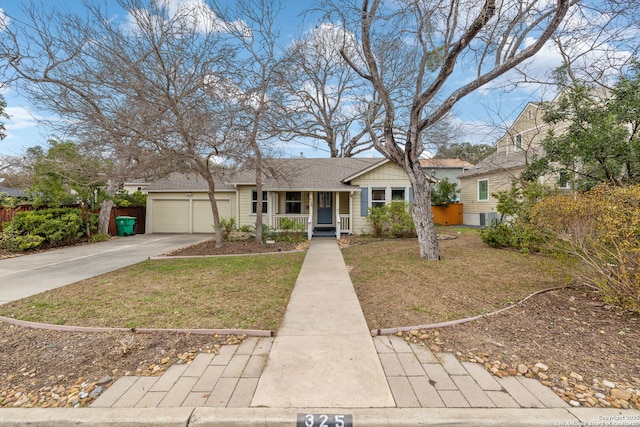 view of front of home featuring a porch, a shingled roof, an attached garage, a front yard, and driveway