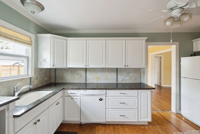 kitchen with white appliances, light wood-style flooring, white cabinetry, and a sink