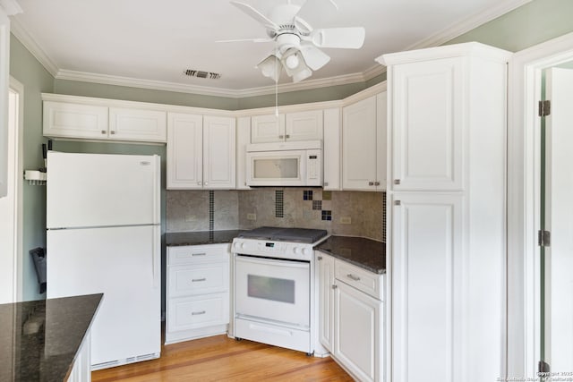 kitchen featuring white appliances, visible vents, white cabinetry, dark stone counters, and light wood finished floors