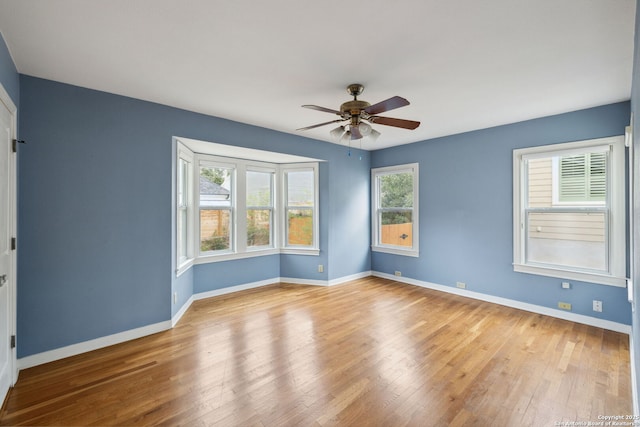 unfurnished room with light wood-style floors, ceiling fan, and baseboards