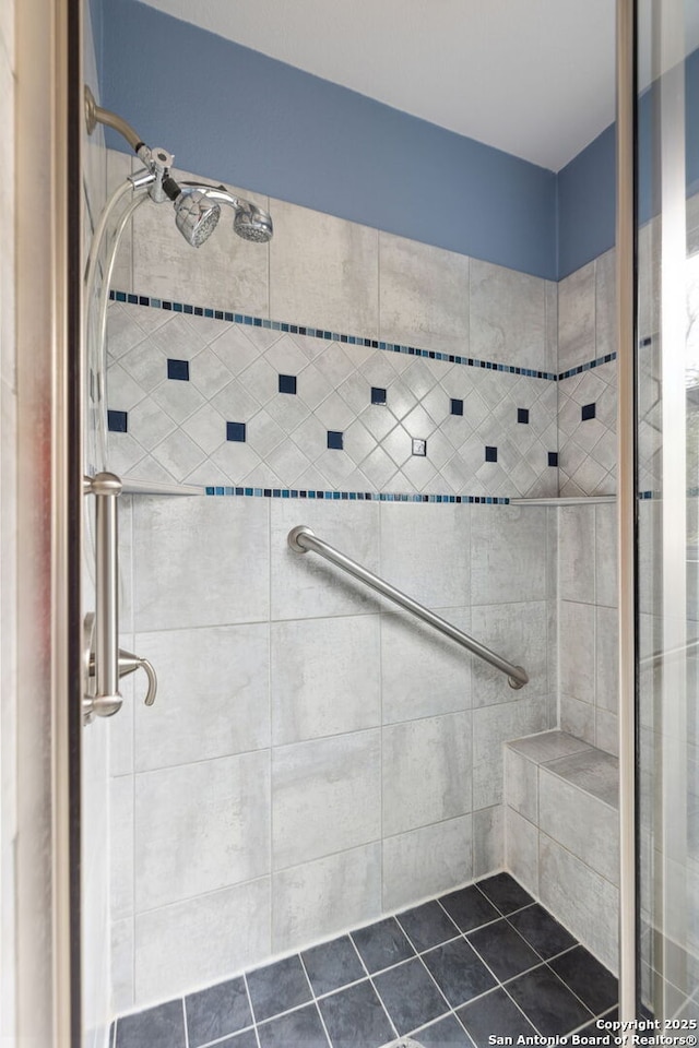 full bath featuring tiled shower and tile patterned floors