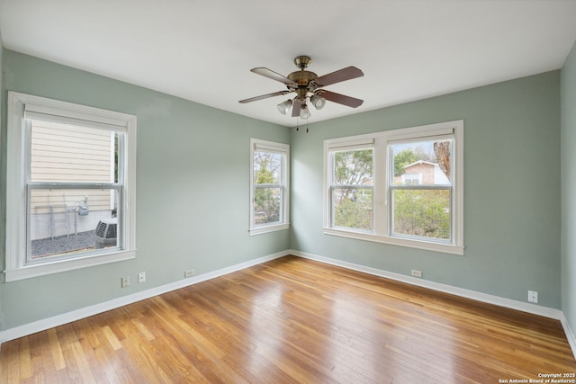 spare room with light wood-style floors, ceiling fan, and baseboards