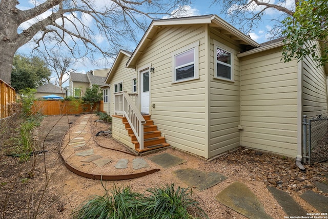 rear view of property featuring fence