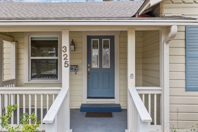 view of exterior entry with a shingled roof