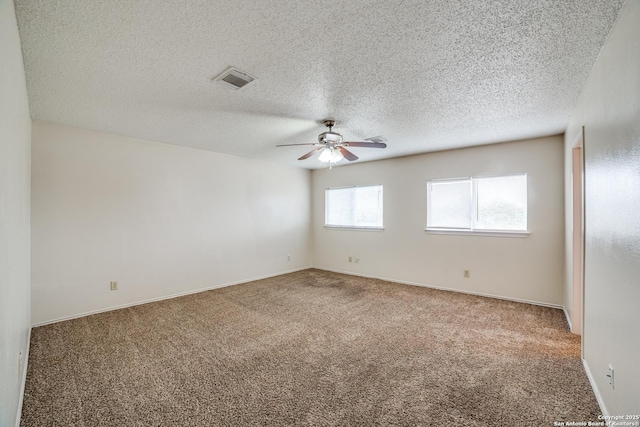 spare room featuring carpet floors, ceiling fan, baseboards, and a textured ceiling