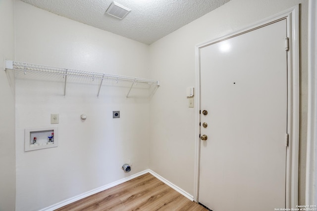 clothes washing area with hookup for a washing machine, laundry area, wood finished floors, visible vents, and electric dryer hookup