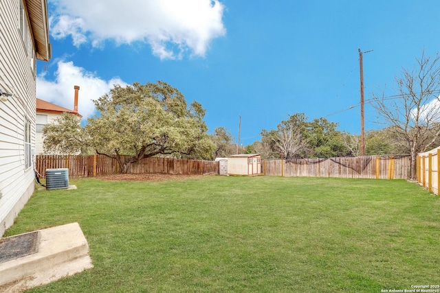 view of yard featuring a shed, an outdoor structure, a fenced backyard, and cooling unit