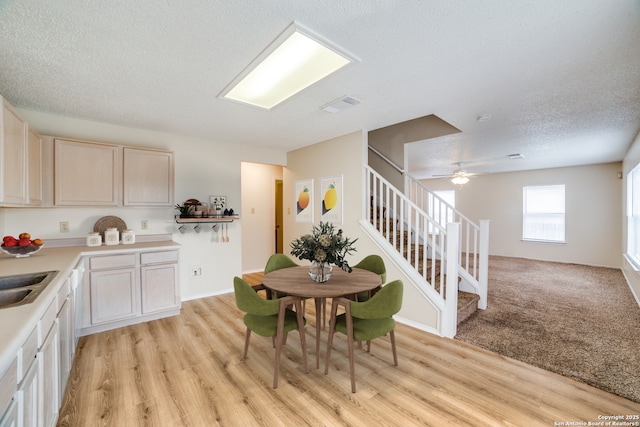 dining area featuring stairs, a textured ceiling, visible vents, and light wood-style floors