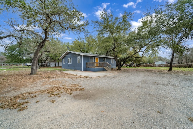 view of front of property featuring driveway and fence