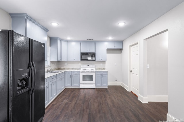 kitchen with black appliances, dark wood-style flooring, a sink, and visible vents