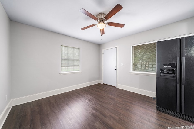 empty room with dark wood-type flooring, baseboards, and a ceiling fan