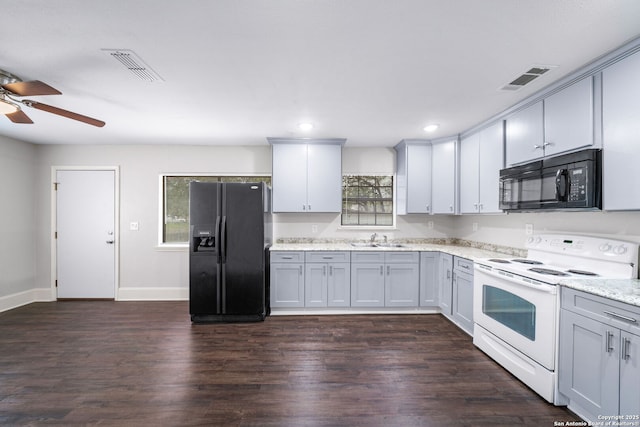 kitchen featuring visible vents, light stone counters, dark wood-type flooring, black appliances, and a sink