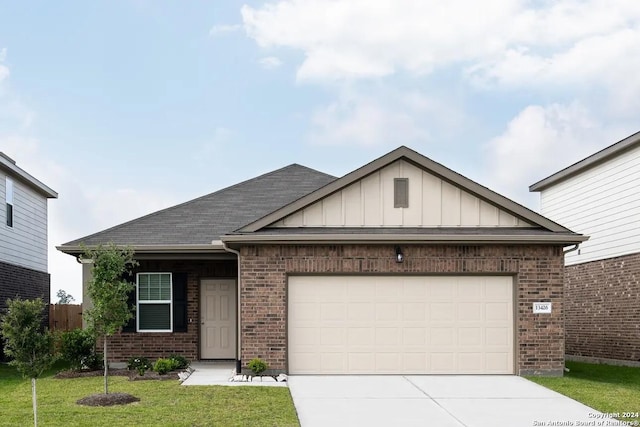 view of front of home featuring board and batten siding, a front yard, brick siding, and a garage