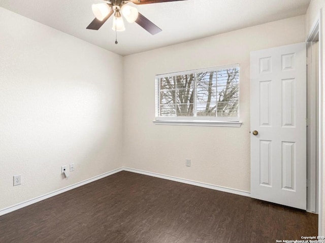 unfurnished room with ceiling fan, baseboards, and dark wood-type flooring