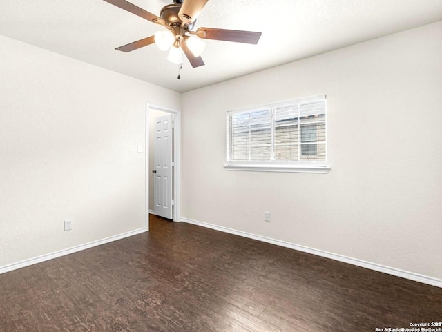 empty room featuring dark wood-type flooring, ceiling fan, and baseboards