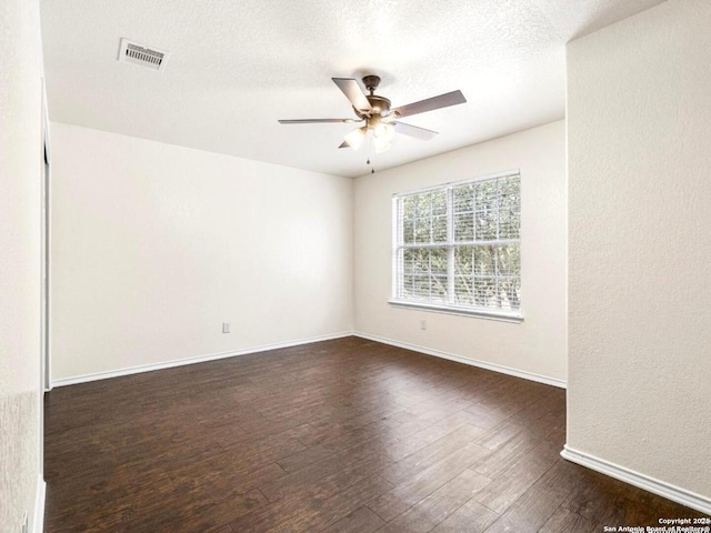 unfurnished room with dark wood finished floors, visible vents, ceiling fan, a textured ceiling, and baseboards