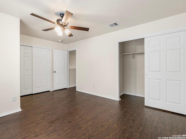 unfurnished bedroom featuring a ceiling fan, baseboards, visible vents, and dark wood-style flooring