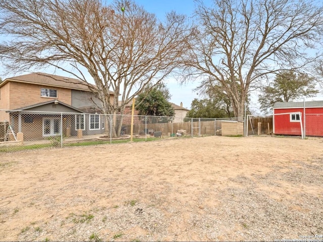 view of yard featuring a storage unit, an outdoor structure, and fence