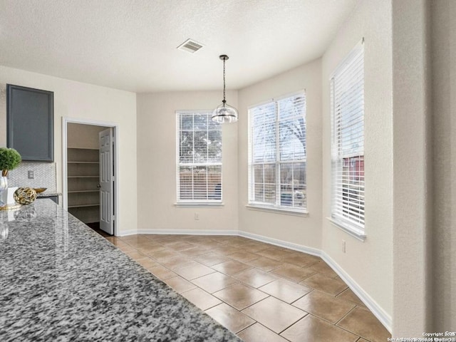 dining space featuring light tile patterned floors, baseboards, visible vents, and a textured ceiling