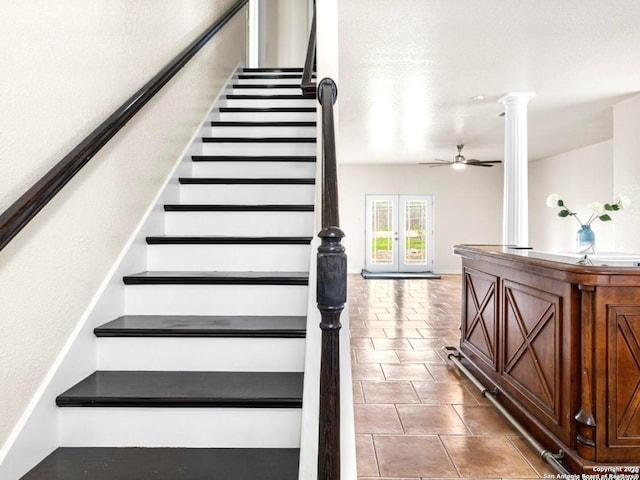 stairway featuring french doors, tile patterned flooring, a ceiling fan, and ornate columns