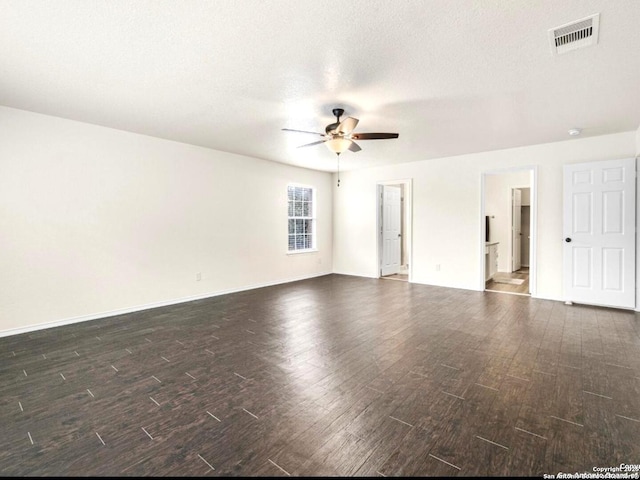 unfurnished room featuring dark wood-style flooring, visible vents, ceiling fan, a textured ceiling, and baseboards