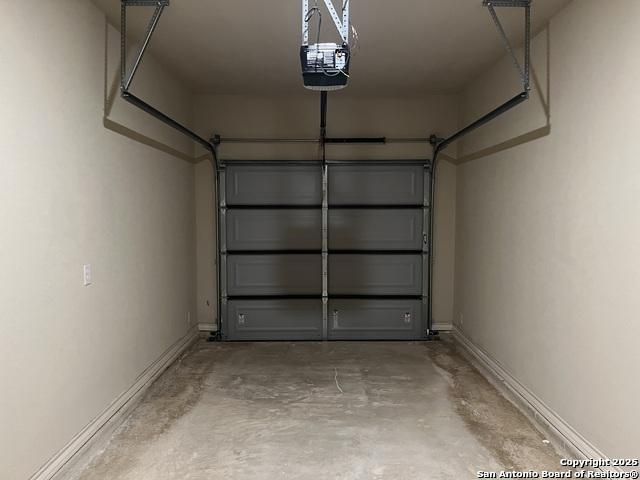 garage with baseboards and a garage door opener