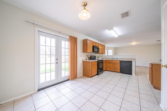 kitchen with french doors, brown cabinets, light countertops, light tile patterned flooring, and black appliances