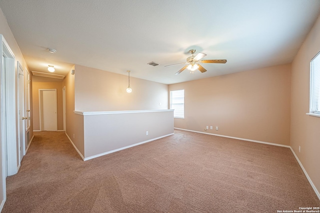 spare room with attic access, visible vents, light carpet, and baseboards