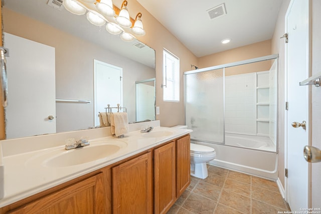 bathroom with visible vents, a sink, and bath / shower combo with glass door