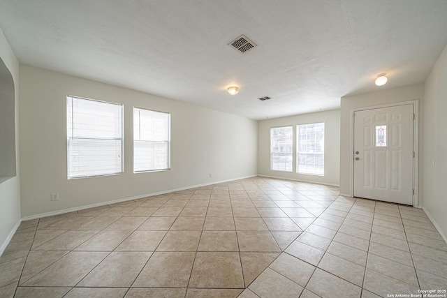 foyer entrance with visible vents, baseboards, and light tile patterned floors