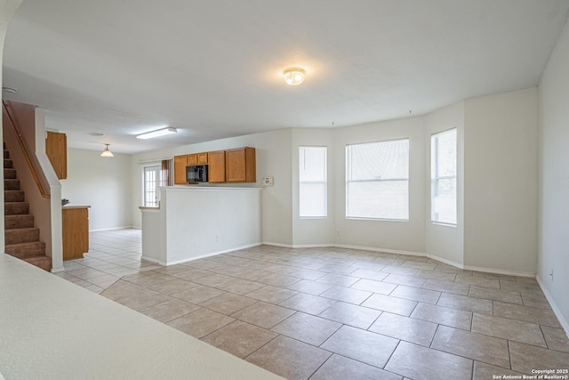 interior space with stairs, baseboards, and light tile patterned floors