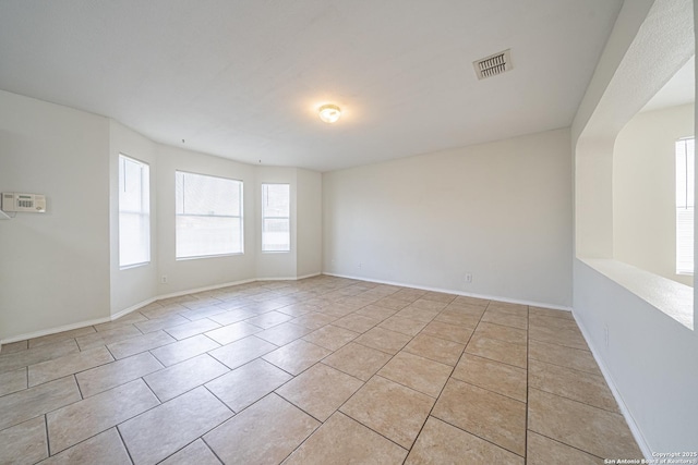 unfurnished room featuring light tile patterned floors, baseboards, and visible vents