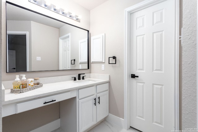 bathroom featuring marble finish floor, vanity, and baseboards