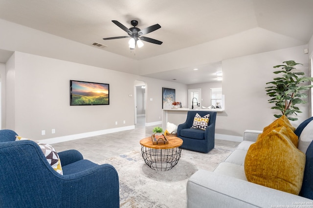 living room with ceiling fan, visible vents, and baseboards