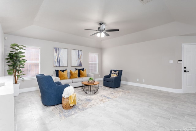 living room featuring visible vents, a ceiling fan, vaulted ceiling, baseboards, and a raised ceiling